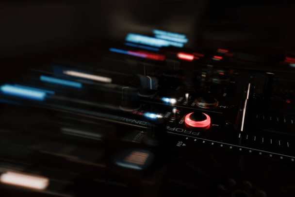 Egy éjszakai felvétel egy DJ-ről, törlőkendőkkel és színes fényekkel keverve. - Fotó, kép