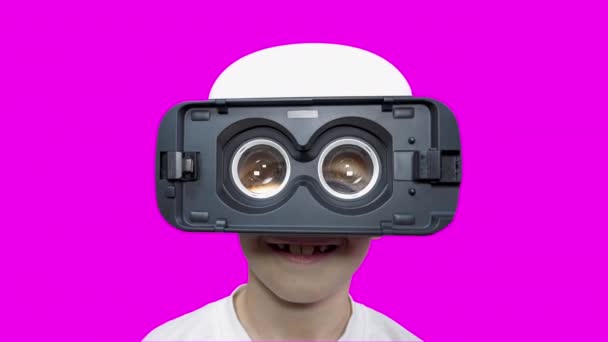 Cheerful boy in virtual reality glasses with huge eyes. Smiling child watching a virtual video. Cyberpunk. Spherical video. Augmented Reality. The boy plays computer games. Future technologies. - Footage, Video