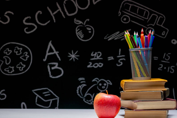 Back to school background with books, pencils and apple on white table - Фото, изображение