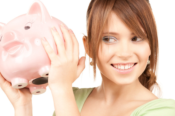 Lovely teenage girl with piggy bank - Фото, изображение