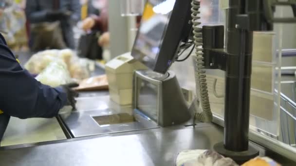 Kassiererin in Handschuhen schlägt Ware an Kasse im Supermarkt, Mittel zum Schutz gegen Coronavirus - Filmmaterial, Video