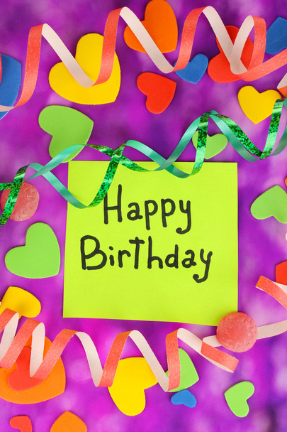 Карточка "С днем рождения" в окружении праздничных элементов на фиолетовом фоне
 - Фото, изображение