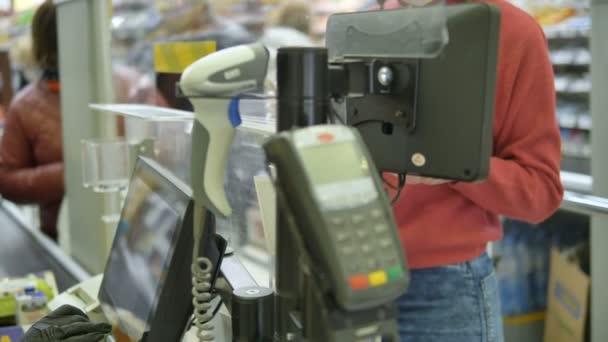 Una donna paga alla cassa in un supermercato con contanti in guanti di gomma. Protezione dal coronavirus
. - Filmati, video