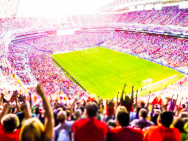 Football- soccer fans cheer their team and celebrate goal in full stadium with open air  with bright lighting beam     -blurred. - Photo, Image