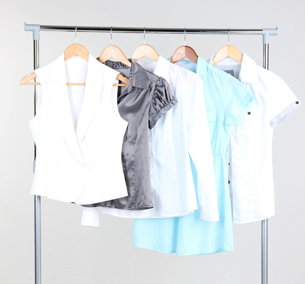 Office female clothes on hangers, on gray background - Fotó, kép