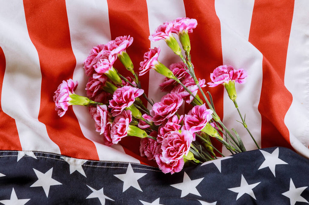 Pink carnation flowers in the USA flag on background, of Remembrance Veterans and Memorial Day - Фото, изображение