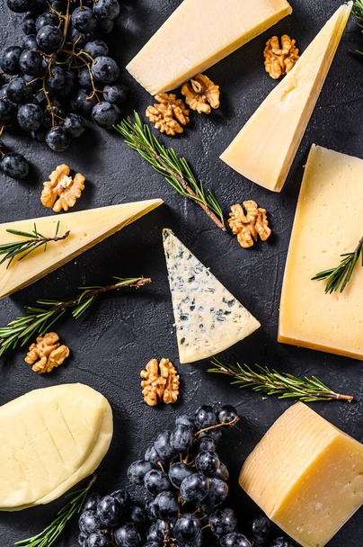 Schöner Hintergrund mit verschiedenen Arten von köstlichem Käse, Walnüssen und Trauben. Ansicht von oben. - Foto, Bild