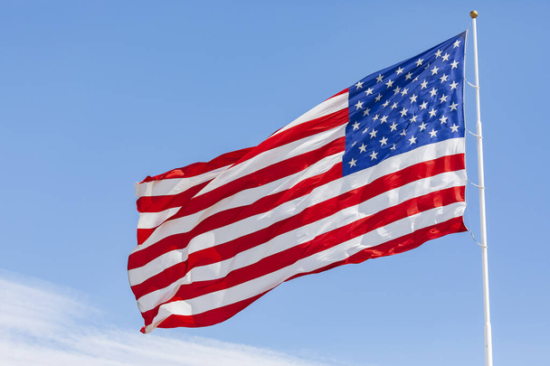 American flag waving in the wind on blue sky, US flag motion close-up, red white blue flag outdoors in sunlight. United States of America national flag. USA stars and stripes - Photo, image