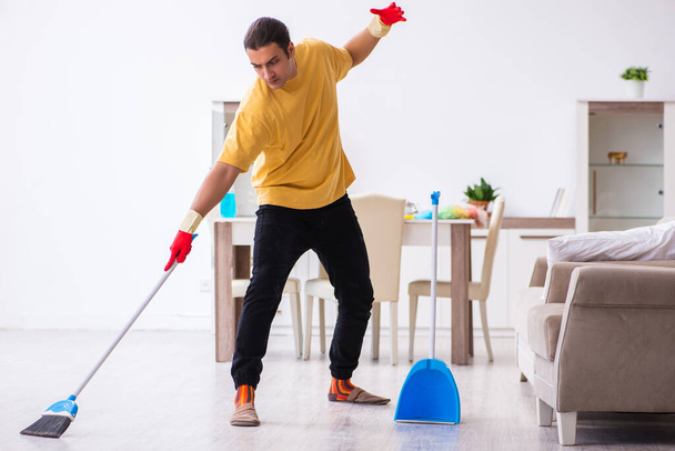 Young male contractor cleaning the house - Fotoğraf, Görsel