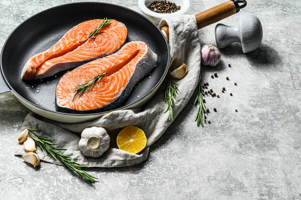 Raw salmon steak in a frying pan. Healthy seafood. Gray background. Top view. Space for text. - Foto, Bild