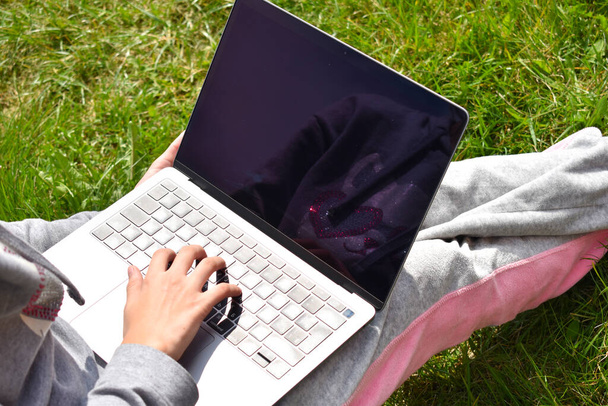 Remote schooling. The child learns on a laptop outdoors. - Foto, afbeelding