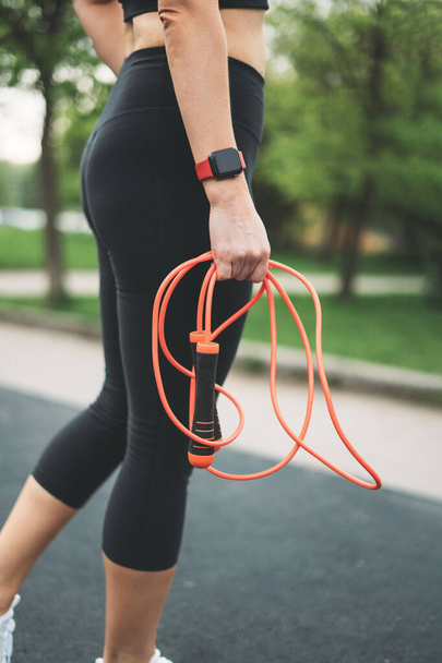 Crop photo of young athletic girl with skipping rope in hands before training - Fotografie, Obrázek