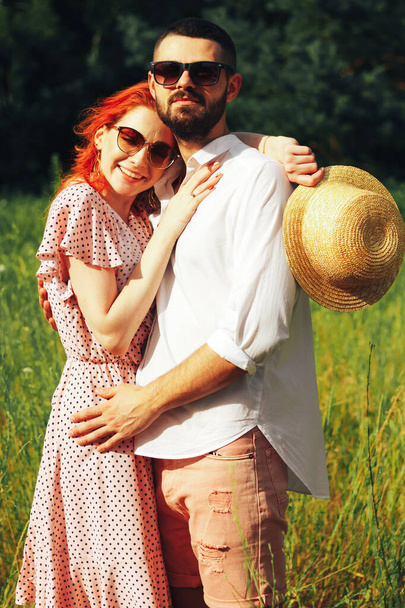 Gelukkig, verliefd stel knuffelende, roodharige meid. minuut om te kussen. date attractie en seksualiteit zonnebril in de zomer - Foto, afbeelding