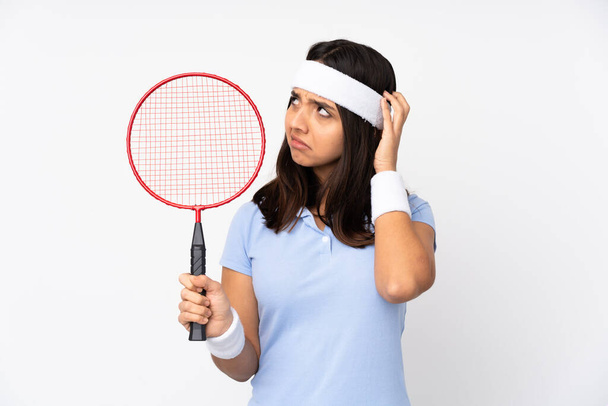 Young badminton player woman over isolated white background having doubts - Foto, afbeelding