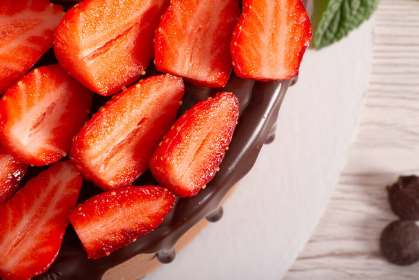 Mousse cake with profiteroles inside and strawberries - Foto, Bild
