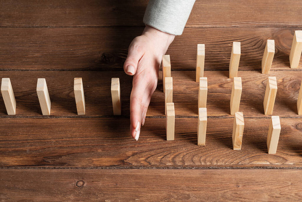 Business woman block domino effect. Business assistance, risk management and stabilisation situation. Intervention in process concept with wooden blocks on table. Protection from economic collapse. - Foto, Imagen