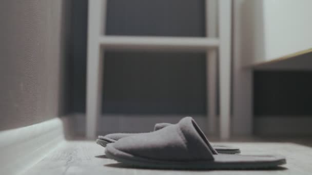Woman getting out of bed, put on grey slippers - Filmati, video