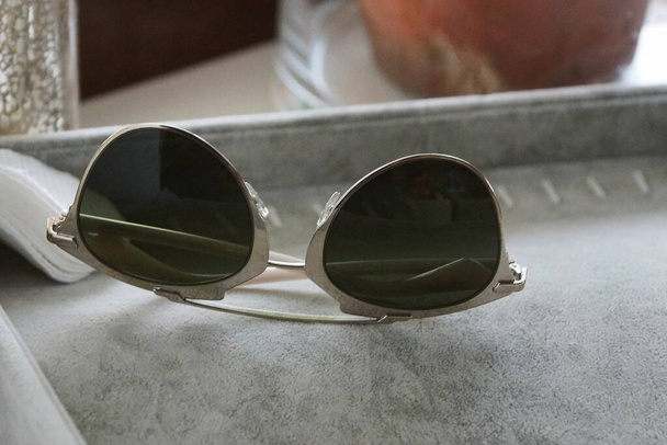 один коричневий сонцезахисний окуляри лежать на сірому столі
 - Фото, зображення