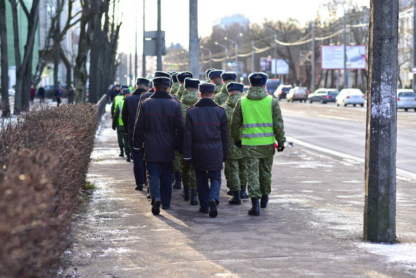 Στρατιωτικοί και αστυνομικοί περπατούν στο πεζοδρόμιο του Μινσκ. - Φωτογραφία, εικόνα