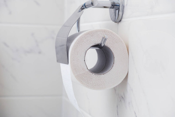 Toilet paper roll on a metal holder. Close up. - Foto, imagen