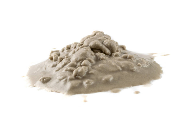 Hromada mokrého písku z boku. Kapající písek pláž texturovaná hromada izolované na bílém pozadí - Fotografie, Obrázek