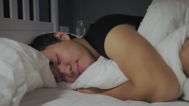 Detailní záběr mladý asijský muž ležící a spící v posteli doma. - Záběry, video