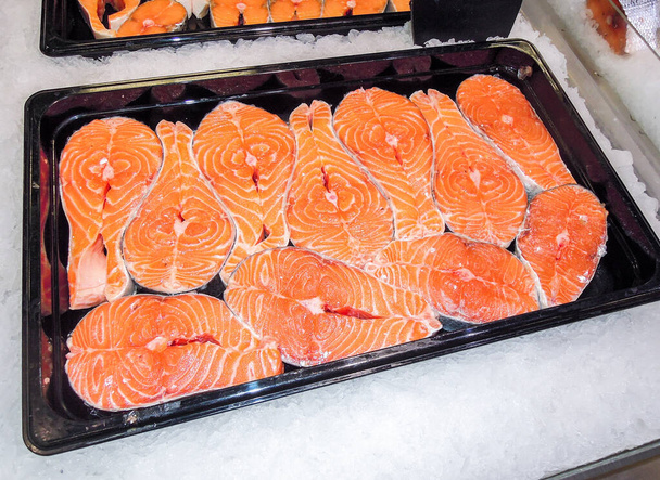 Filetes de salmón fresco en el mostrador. Pescado rojo crudo en venta. Tienda de mariscos
 - Foto, imagen