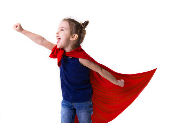 Adorabile ragazzina che vola come un supereroe in t-shirt blu e mantello rosso. Super ragazza. La nuova generazione salva il mondo. Il bene trionfa sul male. Ritratto divertente per bambini - Foto, immagini