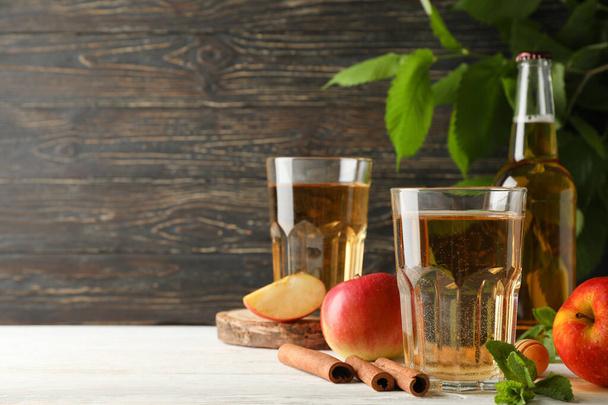 Composition with cider, cinnamon and apples on wooden background - Photo, Image