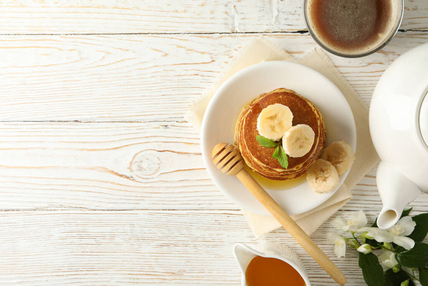 Komposition mit Pfannkuchen auf weißem Holzhintergrund, Draufsicht. Süßes Frühstück - Foto, Bild
