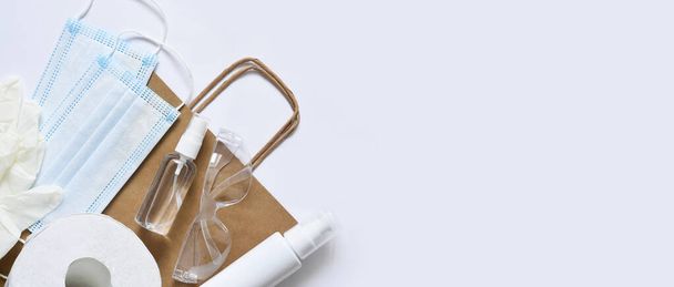 Paper bag with purchase.Virus protection: antiseptic, mask, gloves on white background. Flatly.Pandemic. - Φωτογραφία, εικόνα