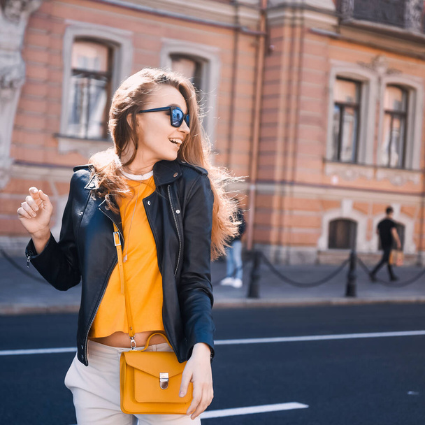close-up portrait of a young sexy girl hipster beautiful blonde  with sunglasses laughing and posing against the backdrop of the St. Petersburg city - 写真・画像