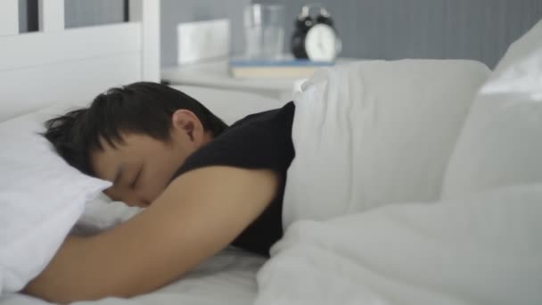 Close up di giovane asiatico uomo sdraiato e dormire nel letto a casa
. - Filmati, video