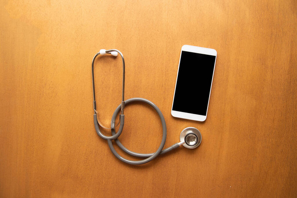 concept heart care on wooden background with smartphone mock up - Foto, Imagem