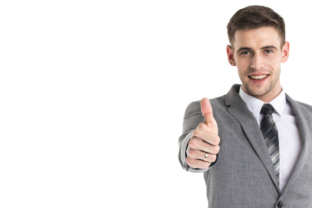 Smiling young businessman with thumb up isolated on white background - Foto, Bild
