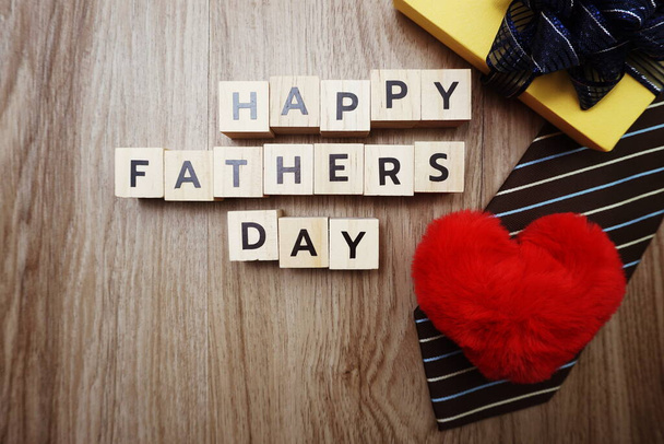 Happy Father's Day alphabet letters with necktie gift box and red heart fluffy on wooden background - Photo, image