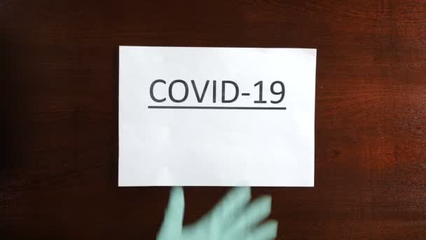 Hand in Schutzhandschuh Nehmen Sie das covid-19 Papier weg und zerknüllen Sie es von der Tür. Ende des Coronavirus und der Pandemie. Nahaufnahme. Keine Beschränkungen mehr. Die Quarantäne endet. 4 k Filmmaterial - Filmmaterial, Video