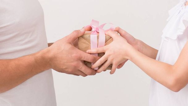 Father and daughter holding present box in hands - Фото, изображение