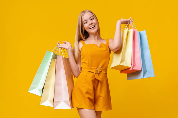 Šťastný dospívající dívka po úspěšném nakupování nosit spoustu papírových sáčků - Fotografie, Obrázek