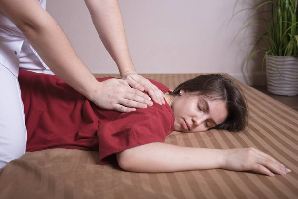 A young girl gets a Thai massage. Firming massage for the female body - Fotó, kép