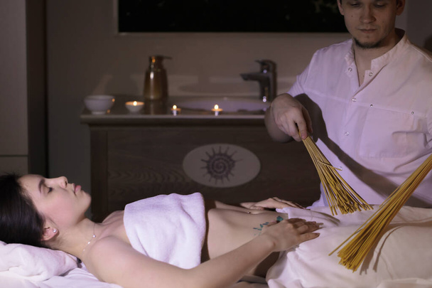 The doctor makes a relaxing massage with a vibro massager for the body and hands of a young girl - Foto, imagen