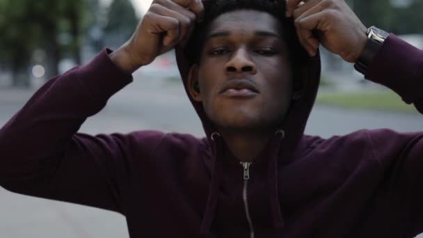 Confident African American man wearing hood in city - Imágenes, Vídeo
