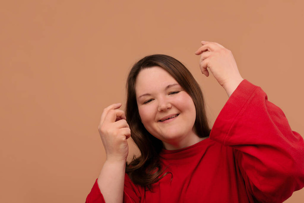 Happy beautiful girl with excess weight. Bright red clothes. - 写真・画像