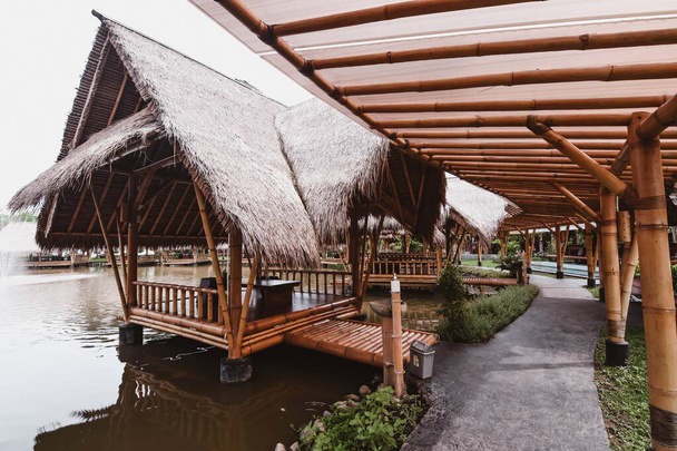Surabaya, Indonésie - 28 mars 2019 : L'atmosphère à l'intérieur du restaurant, le bâtiment fait par le bambou au-dessus de l'étang de poissons nommé Gubug Makan Mang Eking, à Juanda Surabaya, Java Est, Indonésie
 - Photo, image