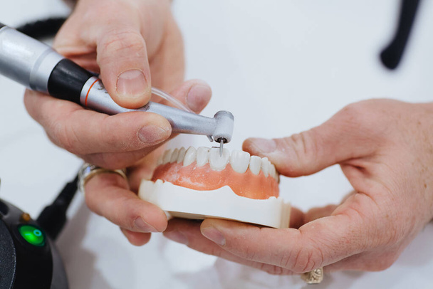 Un odontotecnico elabora un getto della mascella. - Foto, immagini