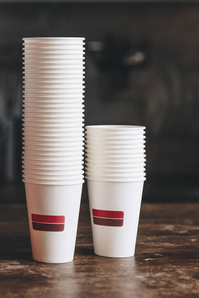 Stack of new take away coffee cups on the wooden table in cafe - Foto, immagini