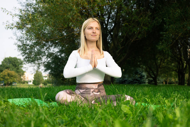 The girl who meditates in the park in good summer weather - Photo, Image