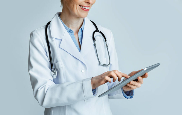 Mosolygó felnőtt nő orvos látszó kórtörténet tabletta - Fotó, kép