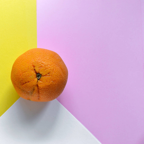 Minimális ételfogalom. Narancs gyümölcs élénk sárga háttérrel. Szabad hely a szövegnek. Első látásra. Minimalizmus. Kreatív narancs. - Fotó, kép