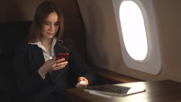 Attractive woman in private jet - Materiał filmowy, wideo